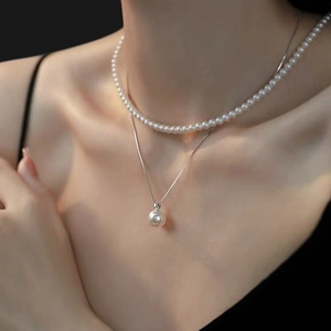 Elegant layered S925 silver necklace with high-luster pearls worn on model neck