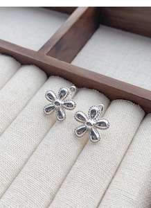 Detail of S925 sterling silver sunflower earrings with beaded edges on velvet display