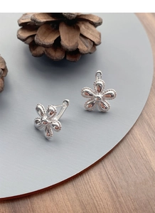 Close-up of S925 sterling silver sunflower stud earrings with polished metallic petals