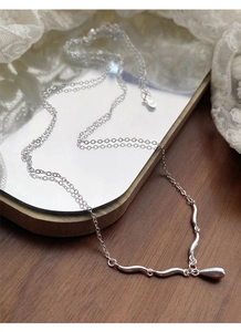 Detail of S925 sterling silver drop necklace on vintage mirror and white lace fabric