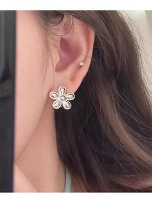 Close-up of a S925 sterling silver sunflower stud earring worn on a woman's earlobe