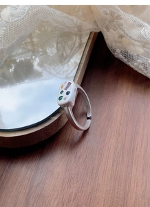 Detail of adjustable silver ring with frosted finish and colorful gemstone inlays