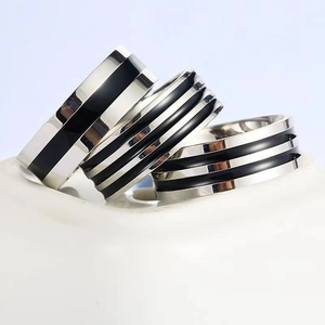Detailed view of polished stainless steel rings with black enamel stripes for men