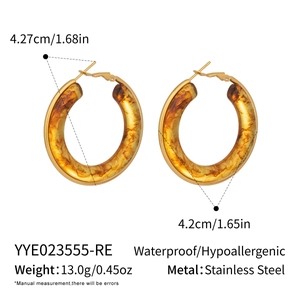 Detail showing amber resin hoop earrings with stainless steel gold accents and 4.2cm size