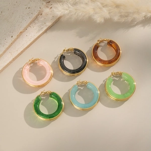 Detailed close-up of colorful resin hoop earrings with gold-plated metal frames