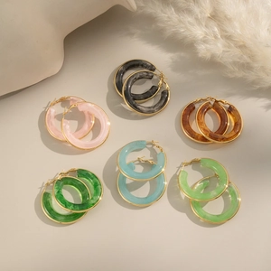 Detailed macro view of resin hoop earrings with marble textures in diverse colors