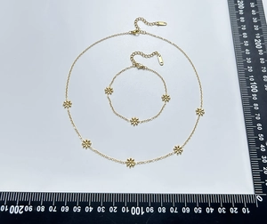 Detailed view of daisy necklace and bracelet set with measurement scale on white background