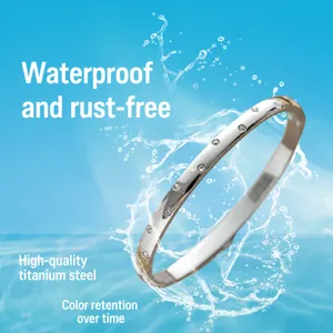 Minimalist shiny titanium steel bangle with embedded stones in a water splash scene