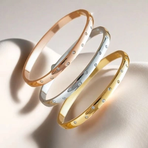Detail of gold, silver, and rose gold titanium steel bangles with sparkling zircons