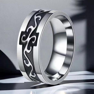 Close-up of 8mm wide stainless steel ring with black engraved tribal cross pattern