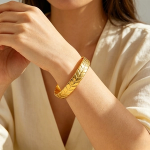 Golden titanium steel wheat ear cuff bracelet with geometric texture on female wrist