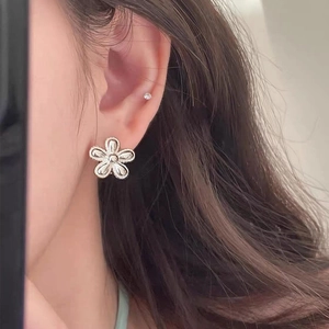 Minimalist S925 sterling silver sunflower stud earring shown on a model ear