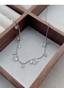 Détail du collier en argent S925 avec perles et pendentifs en zircon sur tissu rustique