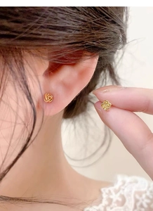 Gros plan de boucles d'oreilles rose doré montrant la texture délicate des pétales