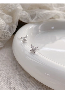 Vue détaillée des boucles d'oreilles papillon en argent S999 avec zircons sur dentelle