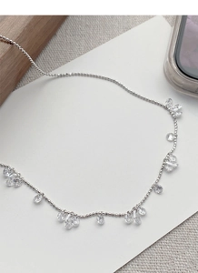 Gros plan d'un collier en argent S925 avec pendentifs en zircone goutte et ronds sur carte