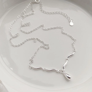 Minimalist S925 sterling silver necklace with teardrop pendant on white ceramic background