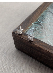 Détail macro de boucles d'oreilles papillon en argent S999 avec cristaux brillants
