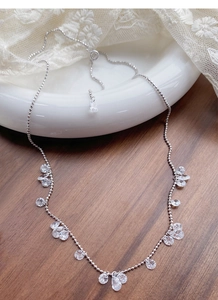 Vue détaillée du collier en argent S925 avec zircons en forme de goutte et ronds sur bois
