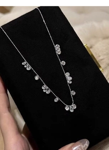 Détail du collier S925 en argent avec breloques en zircone goutte et rondes sur écrin
