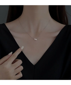 Close-up of minimalist S925 silver double star necklace with sparkling zircon pavé on model