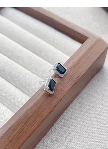 Gros plan sur boucles d'oreilles en zircon noir rectangulaire avec halo argenté sur velours