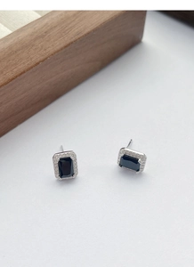 Détail de boucles d'oreilles carrées en zircon noir avec base argentée et cristaux