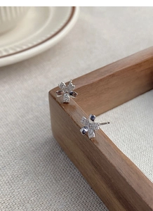 Macro detail of S999 silver cherry blossom earrings with sparkling pave-set stones