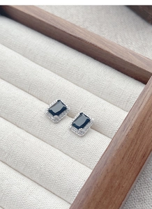Gros plan de boucles d'oreilles rectangulaires en zircon noir sur boîte à bijoux