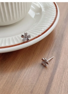 Macro shot of S999 silver cherry blossom stud earrings with sparkling zirconia petals