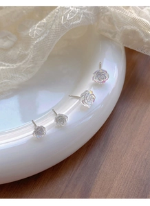 Close-up of S925 silver camellia flower earrings with pearlescent resin finish