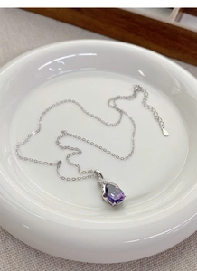 Macro shot of S925 sterling silver necklace featuring a purple teardrop gemstone pendant