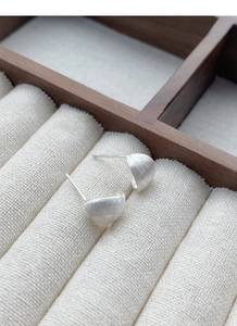 Détail macro de boucles d'oreilles S925 en argent massif avec texture mate brossée