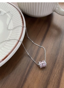 Detailed macro of S925 silver necklace featuring a pink gemstone cylinder pendant