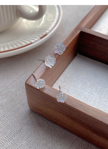 Detailed view of S925 sterling silver camellia earrings with iridescent resin petals