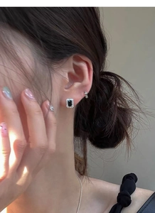 Gros plan de boucles d'oreilles en argent S925 avec zircon noir carré et pierres blanches