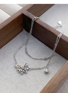 Détail du bracelet double couche en argent S925 avec breloque papillon en zircon coloré