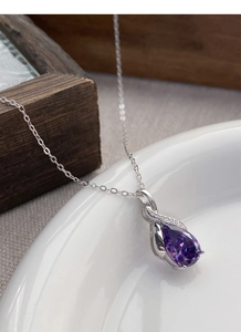 Close-up of S925 silver necklace with purple pear-cut gemstone on minimalist background