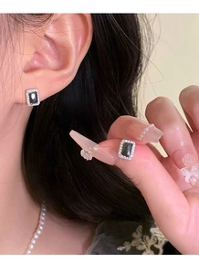 Vue rapprochée des boucles d'oreilles en zircon noir rectangulaire avec halo de cristal