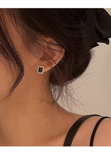 Gros plan de boucles d'oreilles rectangulaires en zircon noir portées par un mannequin