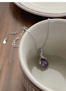 Detail view of S925 sterling silver stamp on the purple teardrop necklace clasp