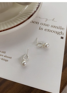Detail of S925 silver irregular pearl earring on elegant white background artistic card