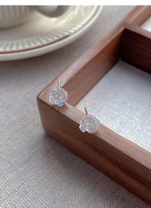 Detailed close-up of S925 silver camellia earrings with iridescent pearlescent finish