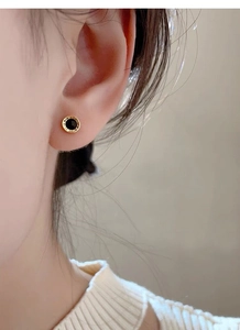 Macro shot of S999 silver roman numeral stud earring with black inlay on model