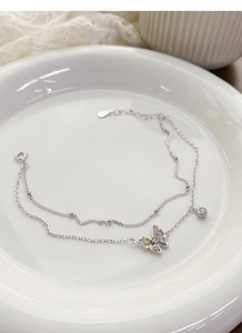 Détail macro du bracelet double couche en argent S925 avec breloques papillon en zircon