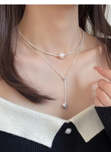 Detail of S925 silver double layered necklace with pearl and silver heart pendant