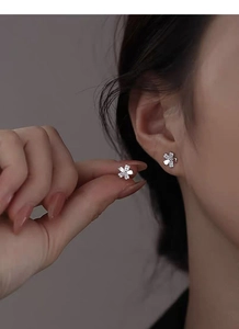 Detail of S999 silver cherry blossom stud earrings with zircons worn by a model