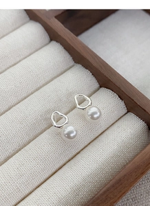 Detailed close-up of S925 sterling silver irregular geometric pearl stud earrings in a box