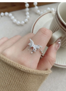 Detail of 925 sterling silver butterfly ring with cubic zirconia on a model's hand