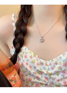 Detailed view of S925 sterling silver heart necklace with pink gemstone on female model